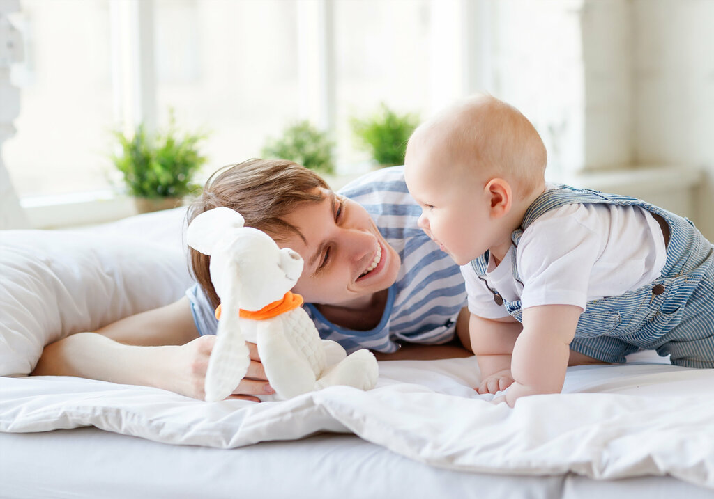 Vater und Sohn spielen auf dem Bett.