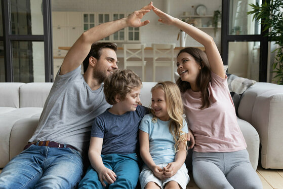 Familie macht mit den Händen ein Dach als Schutz