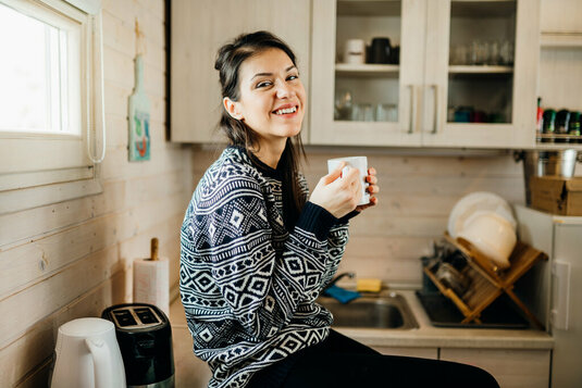 tiny-house-kleines-haus-wohnung-wohnen-010 Glückliche Frau in einer kleinen Küche.