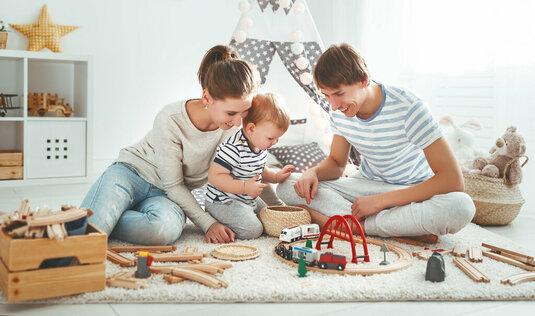 Mutter und Vater spielen zusammen mit ihrem Kind im Kinderzimmer