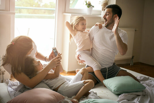 Glückliche Familie spielt im Wohnzimmer