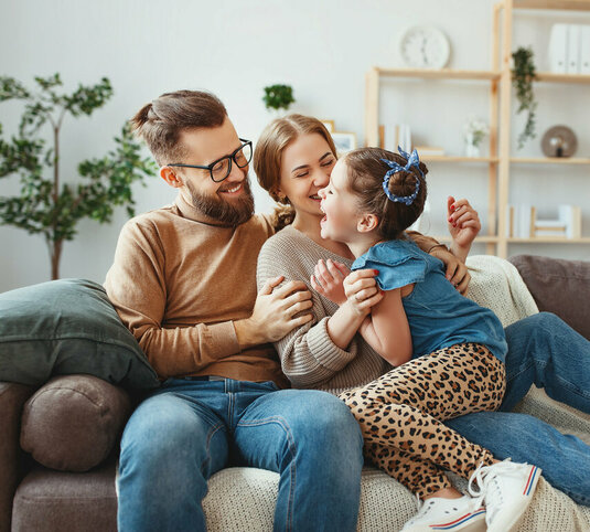 Glückliche Familie die sich auf der Couch wohlfühlt.