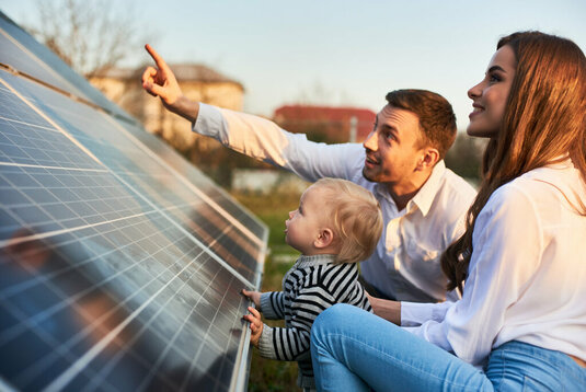 Mann zeigt seiner Familie die Photovoltaikanlage.