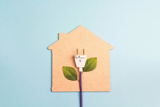 Collage bestehend aus Haus aus Pappe mit Stromkabel und Blättern