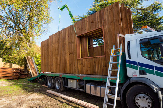 Fertighauselemente aus Holz auf einem Lastkraftwagen.