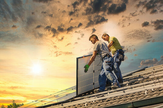 Zwei Männer bauen Solaranlage