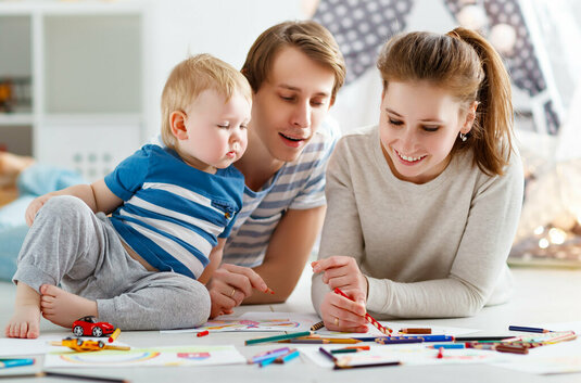 Glückliche Familie, Mutter Vater und Baby malen zusammen.