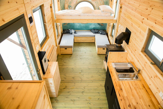 Kompakte Inneneinrichtung des Tiny Houses mit Bett und Küche