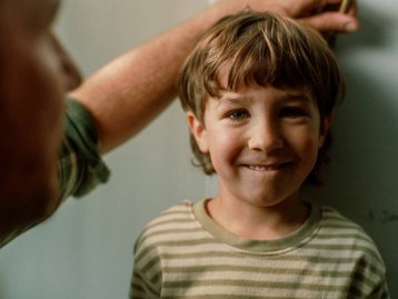 Fröhliches Familienbild mit Kind und Vater – emotionale Nähe beim Hauskauf vor Ort